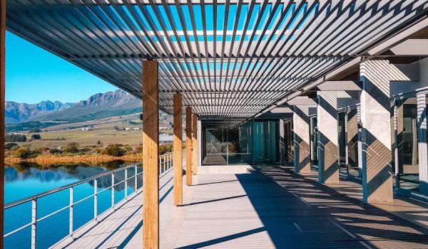 a walkway with a bench under a metal roof