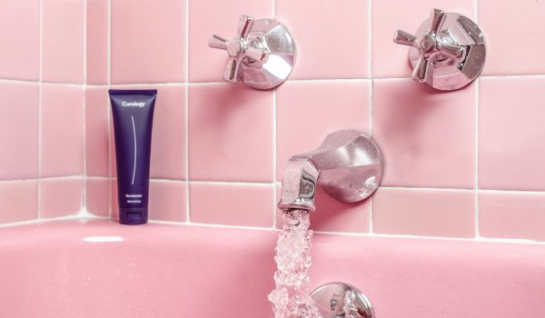 a pink bathtub with a faucet and soap dispenser